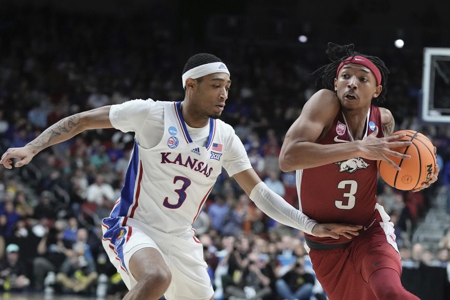 Ta3 tries to get past Kansas' Dajuan Harris Jr. during the second half of a second-round college basketball game in the NCAA Tournament Saturday, March 18, 2023, in Des Moines, Iowa. (AP Photo/Morry Gash)
