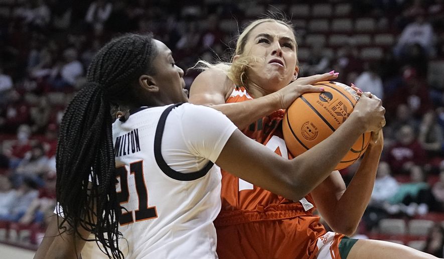 Miami&#x27;s Haley Cavinder (14) is defended by Oklahoma State&#x27;s Terryn Milton (21) during the first half of a first-round college basketball game in the women&#x27;s NCAA Tournament Saturday, March 18, 2023, in Bloomington, Ind. (AP Photo/Darron Cummings)