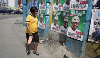 A woman walks past election campaign posters of incumbent governor of Lagos state Babajide Olusola Sanwo-Olu, on a street in Lagos, Nigeria, Thursday, March 16, 2023. Nigeria&#x27;s electoral commission has concluded the deployment of staffers and materials for the nation&#x27;s gubernatorial election as the citizens prepare to elect new governors with mixed feelings after a disputed presidential vote. (AP Photo/Sunday Alamba)
