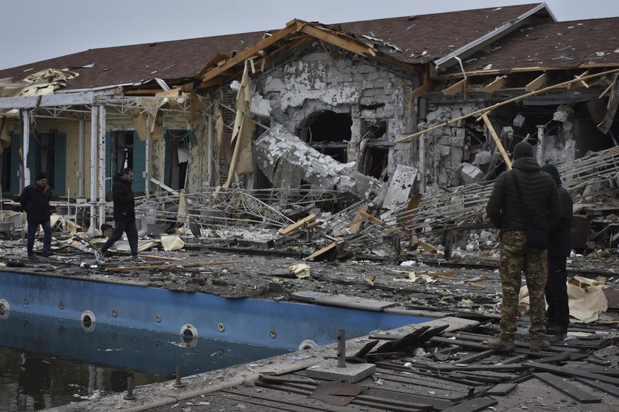 People inspect a damaged restaurant after Russian shelling hit in Zaporizhzhia, Ukraine, Saturday, March 18, 2023. (AP Photo/Andriy Andriyenko)