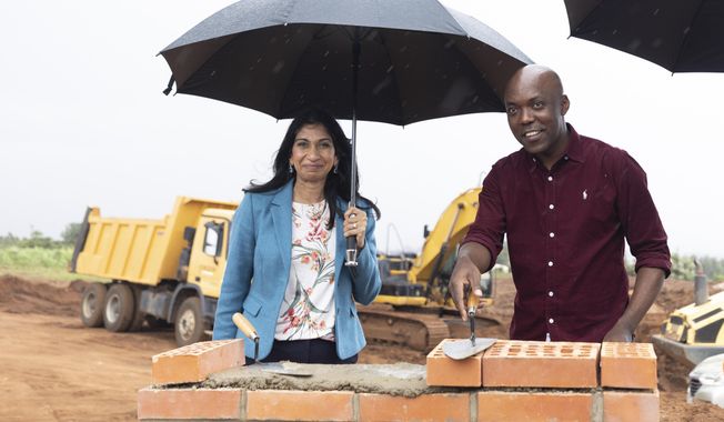 Britain&#x27;s Home Secretary Suella Braverman, left, and Rwanda&#x27;s Minister of Infrastructure Ernest Nsabimana, right, lay bricks at another housing development for migrants, in the capital Kigali, Rwanda Sunday, March 19, 2023. Britain&#x27;s government said Sunday that it could start deporting asylum-seekers to Rwanda in the next few months — but only if U.K. courts rule that the controversial policy is legal. (AP Photo)