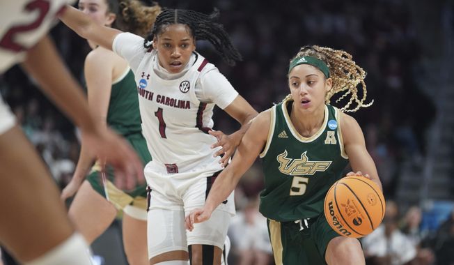 South Florida guard Elena Tsineke (5) dribbles the ball against South Carolina guard Zia Cooke (1) during the first half in a second-round college basketball game in the NCAA Tournament, Sunday, March 19, 2023, in Columbia, S.C. (AP Photo/Sean Rayford)