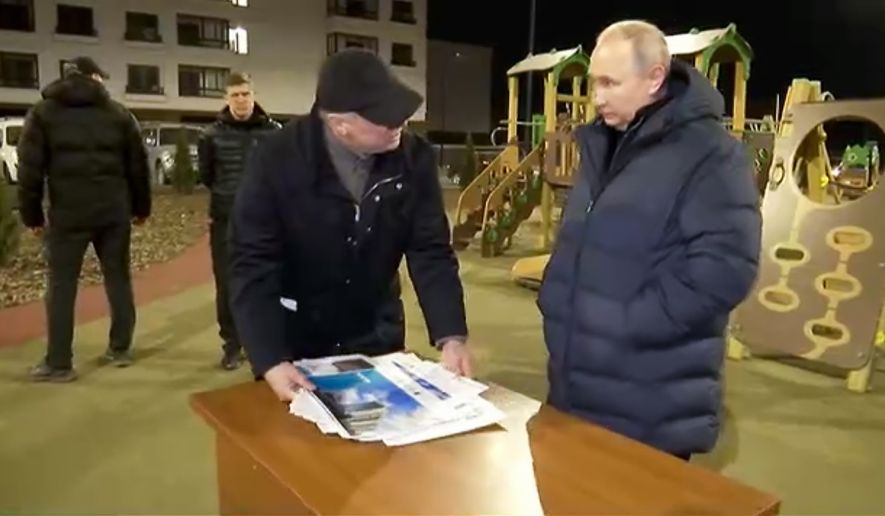 In this photo taken from video released by Russian Presidential Press Office on Sunday, March 19, 2023, Russian President Vladimir Putin, right, listens to Russian Deputy Prime Minister Marat Khusnullin at a newly built neighborhood during their visit to Mariupol in Russian-controlled Donetsk region, Ukraine. Putin has traveled to Crimea to mark the ninth anniversary of the Black Sea peninsula&#x27;s annexation from Ukraine. (Russian Presidential Press Office via AP)