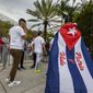A man wearing a Cuban flag bearing the slogan of Patria y Vida walks toward the stadium before a World Baseball Classic game between between Cuba and the United States, Sunday, March 19, 2023, in Miami. (Jose A. Iglesias/Miami Herald via AP)
