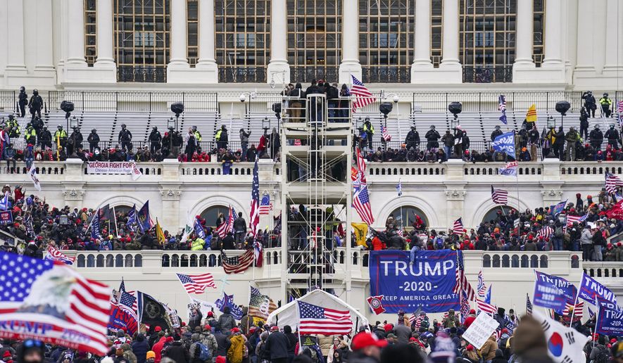 Insurrectionists loyal to President Donald Trump breach the U.S. Capitol in Washington, on Jan. 6, 2021. Four people associated with the Oath Keepers were convicted on Monday, March 20, 2023, of conspiracy and obstruction charges stemming from the attack on the U.S. Capitol in the latest trial involving members of the far-right antigovernment extremist group. (AP Photo/John Minchillo)