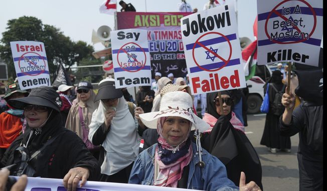 Protesters march during a protest in Jakarta, Indonesia, Monday, March 20, 2023. Hundreds of conservative Muslims have marched to the streets Monday in Indonesia&#x27;s capital to protest against the Israeli team&#x27;s participation in the FIFA World Cup Under-20 in Indonesia.(AP Photo/Achmad Ibrahim)