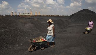 Women push wheelbarrows atop a coal mine dump at the coal-powered Duvha power station, near Emalahleni east of Johannesburg, Nov. 17, 2022. Humanity still has a chance, close to the last one, to prevent the worst of climate change’s future harms, a top United Nations panel of scientists said Monday, March 20, 2023. But doing so requires quickly slashing carbon pollution and fossil fuel use. (AP Photo/Denis Farrell, File)