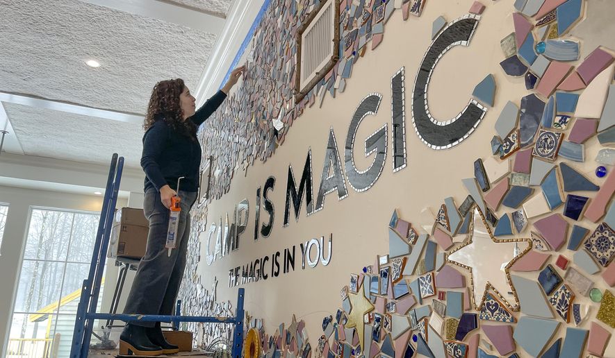 Artist Mia Schon finishes a mural in one of the activity rooms of the Hole In the Wall Gang Camp, March 2, 2023, in Ashford, Conn. Two years after a fire devastated Paul Newman&#x27;s camp for seriously ill children, the rebuilt camp center is opening. The new $4.5 million center has twice the space with more accessibility and new amenities such as a quiet sensory room, a dedicated room with a fireplace for parents and caregivers, and an emergency storm shelter and cistern, in case of another fire.(AP Photo/Pat Eaton Robb)
