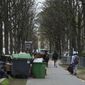 People walk past uncollected garbage in Paris, March 20, 2023 as strikes continue with uncollected garbage piling higher by the day. (AP Photo/Aurelien Morissard, File)