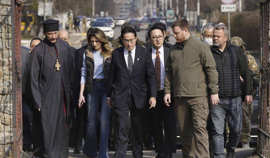 Japanese Prime Minister Fumio Kishida, center, arrives at a church in Bucha, a town outside Kyiv that became a symbol of Russian atrocities against civilians, in Ukraine, Tuesday, March 21, 2023.(Iori Sagisawa/Kyodo News via AP)