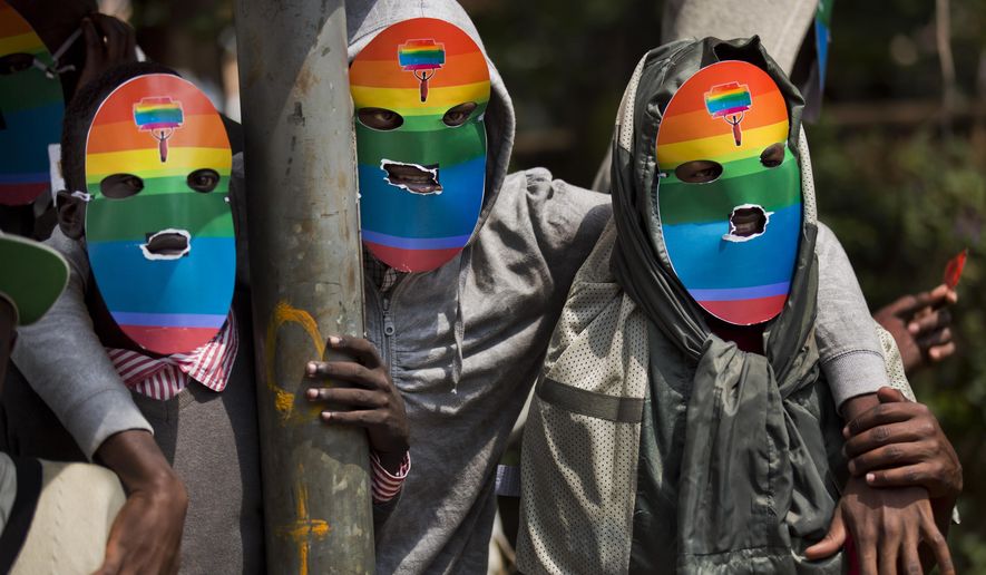 FILE - Kenyan gays and lesbians and others supporting their cause wear masks to preserve their anonymity as they stage a rare protest against Uganda&#x27;s tough stance against homosexuality and in solidarity with their counterparts there, outside the Uganda High Commission in Nairobi, Kenya on Feb. 10, 2014. Ugandan lawmakers passed a bill Tuesday, March 21, 2023 prescribing jail terms of up to 10 years for offenses related to same-sex relations, responding to popular sentiment but piling more pressure on the East African country&#x27;s LGBTQ community. (AP Photo/Ben Curtis, File)