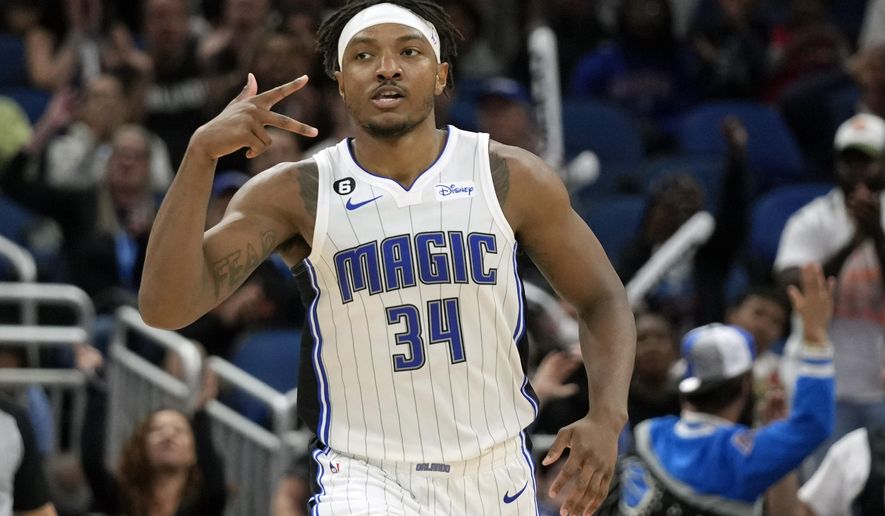 Orlando Magic&#x27;s Wendell Carter Jr. (34) holds out three fingers after sinking a 3-point shot against the Washington Wizards during the second half of an NBA basketball game, Tuesday, March 21, 2023, in Orlando, Fla. (AP Photo/John Raoux)