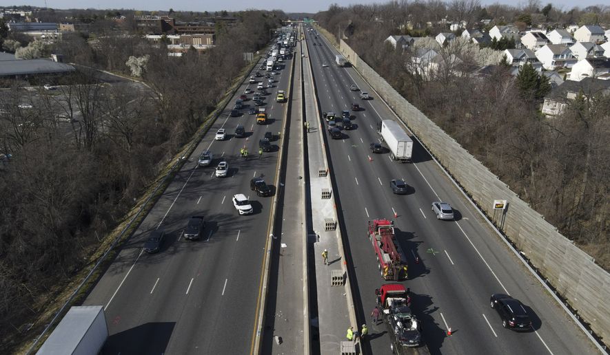 Emergency personnel work at the scene of a fatal crash along Interstate 695 on Wednesday, March 22, 2023, near Woodlawn, Md. Multiple people were killed when a passenger vehicle pulled into a work zone along the Baltimore beltway and struck construction workers there, Maryland State Police said Wednesday. (AP Photo/Julio Cortez)