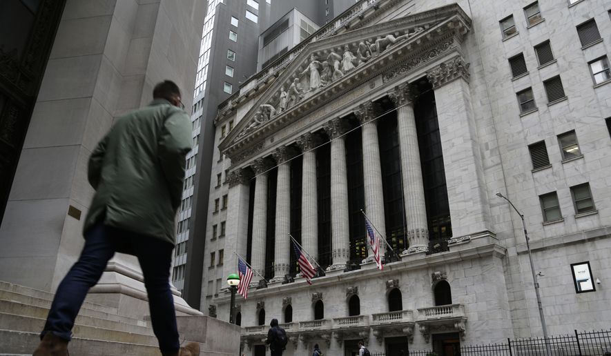 People pass the front of the New York Stock Exchange in New York, on Wednesday, March 22, 2023. European shares have opened mixed after a day of gains in Asia ahead of a decision by the Federal Reserve on interest rates. (AP Photo/Peter Morgan