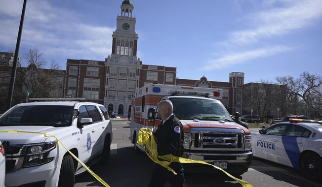 Emergency personnel remove police tape outside East High School after a school shooting, Wednesday, March 22, 2023, in Denver. (Hyoung Chang/The Denver Post via AP)