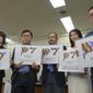 LGBTQ activists hold up cards showing a logo each of their newly founded a civil engagement group Pride7, or P7, for the upcoming Group of Seven Summit that Japan hosts in May, to make policy proposals, including a demand that Japan enact anti-discrimination law to guarantee equal rights for them, at a news conference at the Ministry of Health, Labor and Welfare in Tokyo Wednesday, March 22, 2023.(AP Photo/Mari Yamaguchi)