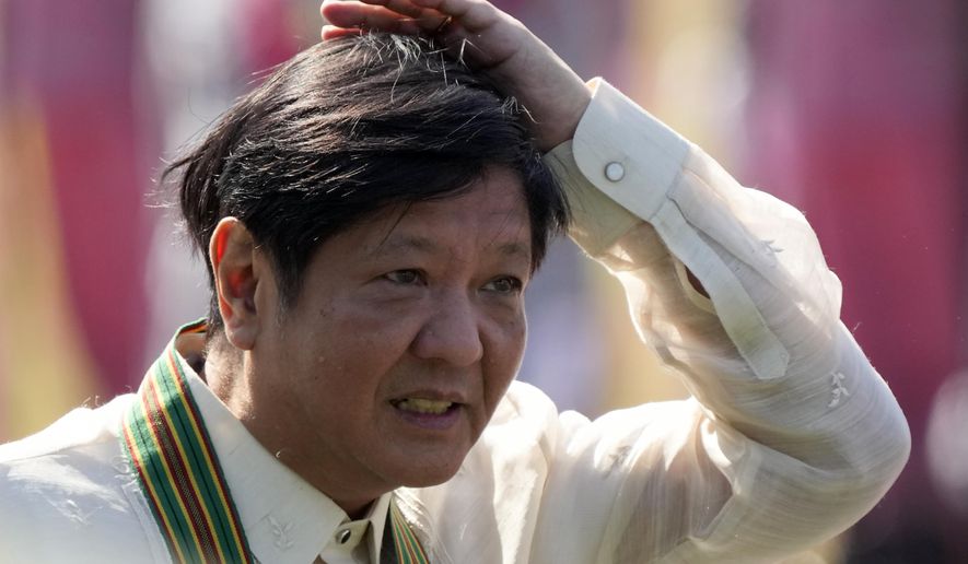 Philippine President Ferdinand Marcos Jr. arranges his hair as he arrives at the 126th founding anniversary of the Philippine Army at Fort Bonifacio in Taguig, Philippines on Wednesday, March 22, 2023. (AP Photo/Aaron Favila)