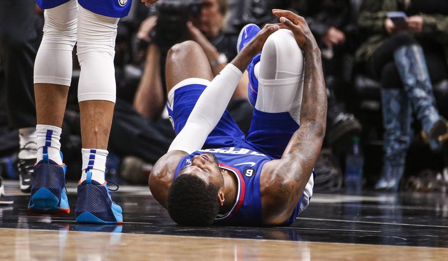 Los Angeles Clippers forward Paul George, right, lies on the court after an injury during the second half of an the team&#x27;s NBA basketball game against the Oklahoma City Thunder on Tuesday, March 21, 2023, in Los Angeles. (AP Photo/Ringo H.W. Chiu)