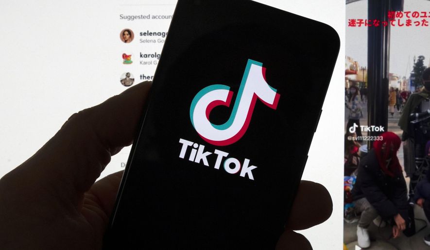 The TikTok logo is seen on a mobile phone in front of a computer screen which displays the TikTok home screen, Saturday, March 18, 2023, in Boston. TikTok&#x27;s CEO plans to tell Congress that the video-sharing app is committed to user safety, data protection and security, and keeping the platform free from Chinese government influence.(AP Photo/Michael Dwyer, File)