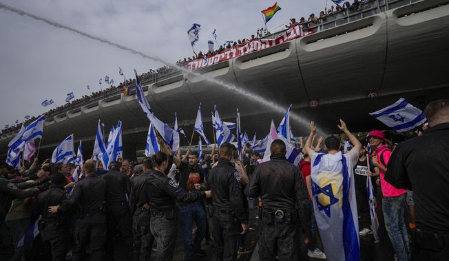 Israeli police use water cannon to disperse Israelis protest against plans by Prime Minister Benjamin Netanyahu&#x27;s government to overhaul the judicial system in Tel Aviv, Israel, Thursday, March 23, 2023. (AP Photo/Ohad Zwigenberg)