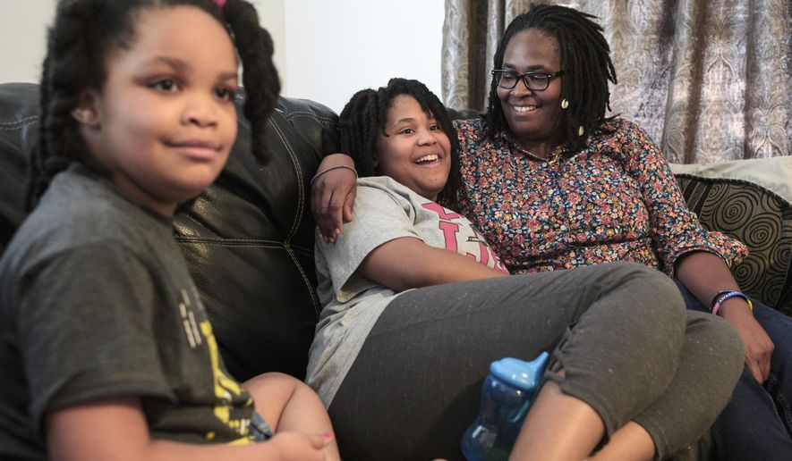 Deleah Payne, 12, center, spends time with her mother Delisa, right, and 6-year-old sister Delynn, left, as they watch movie clips on their living room television in Evansville, Ind., Tuesday evening, Aug. 27, 2019. Deleah and Delynn were both diagnosed with autism. For the first time, autism is being diagnosed more frequently in Black and Hispanic children than in white kids in the U.S., the Centers for Disease Control and Prevention said Thursday, March 23, 2023. (Sam Owens/Evansville Courier &amp; Press via AP, File)