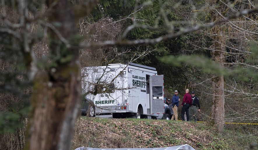 Law enforcement officials work at the scene along Wooding Road on Wednesday, March 22, 2023, east of Washougal, Wash. Authorities found two bodies believed to be those of a missing Vancouver woman and her 7-year-old daughter in a brushy area farther down Wooding Road. (Amanda Cowan/The Columbian via AP)
