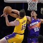 Los Angeles Lakers guard Austin Reaves, left, shoots as Phoenix Suns forward Darius Bazley defends during the first half of an NBA basketball game Wednesday, March 22, 2023, in Los Angeles. (AP Photo/Mark J. Terrill)