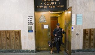 New York City police officers with the canine unit sweep the Manhattan criminal court building before it opens, Thursday, March 23, 2023, in New York. A New York grand jury investigating Trump over a hush money payment to a porn star appears poised to complete its work soon as law enforcement officials make preparations for possible unrest in the event of an indictment. (AP Photo/Mary Altaffer)
