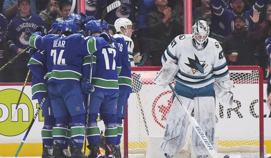 Vancouver Canucks&#x27; Anthony Beauvillier, from left to right, Ethan Bear, Elias Pettersson, Filip Hronek and Andrei Kuzmenko celebrate Kuzmenko&#x27;s goal against San Jose Sharks goalie James Reimer during the first period of an NHL hockey game in Vancouver, British Columbia, Thursday, March 23, 2023. (Darryl Dyck/The Canadian Press via AP)