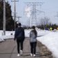 People walk on a trail at the Montissippi County Park near the Xcel Energy Monticello Generating Plant, a nuclear power plant, in Monticello, Minn., on Friday, March 24, 2023. (Renee Jones Schneider/Star Tribune via AP)
