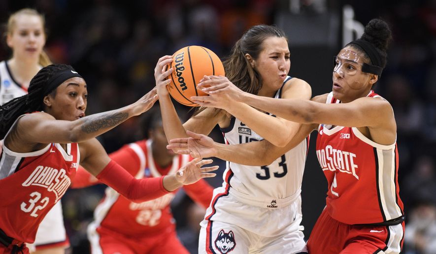 UConn guard Caroline Ducharme (33) holds onto the ball as Ohio State&#x27;s Cotie McMahon (32) and Taylor Thierry (2) attempt to steal possession during the second quarter of a Sweet 16 college basketball game of the NCAA Tournament in Seattle, Saturday, March 25, 2023. (AP Photo/Caean Couto)