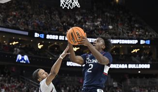 UConn guard Tristen Newton (2) shoots while defended by Gonzaga guard Rasir Bolton in the first half of an Elite 8 college basketball game in the West Region final of the NCAA Tournament, Saturday, March 25, 2023, in Las Vegas. (AP Photo/David Becker)