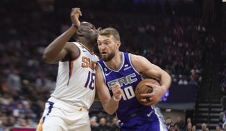 Sacramento Kings forward Domantas Sabonis (10) is defended by Phoenix Suns center Bismack Biyombo (18) as he drives to the basket in the first quarter in an NBA basketball game in Sacramento, Calif., Friday, March 24, 2023. (AP Photo/José Luis Villegas)