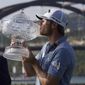 Sam Burns, right, kisses his trophy after defeating Cameron Young in the final match at the Dell Technologies Match Play Championship golf tournament in Austin, Texas, Sunday, March 26, 2023. Michael Dell, left, presented the trophy. (AP Photo/Eric Gay) **FILE**