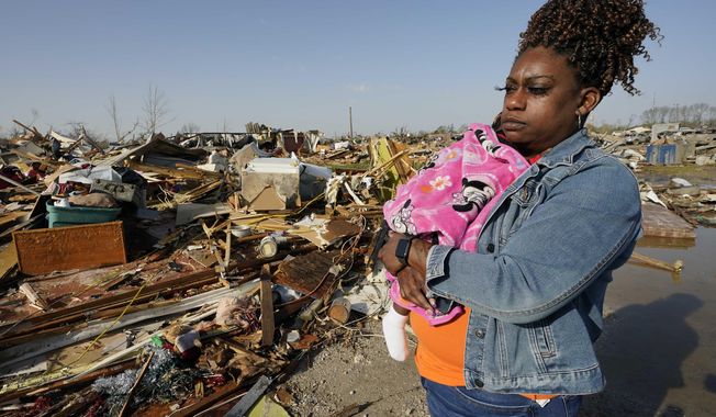 Wonder Bolden cradles her year-old granddaughter Journey Bolden as she surveys the remains of her mother&#x27;s tornado demolished mobile home in Rolling Fork, Miss., Saturday March 25, 2023. Emergency officials in Mississippi say several people have been killed by tornadoes that tore through the state on Friday night, destroying buildings and knocking out power as severe weather produced hail the size of golf balls moved through several southern states. (AP Photo/Rogelio V. Solis)