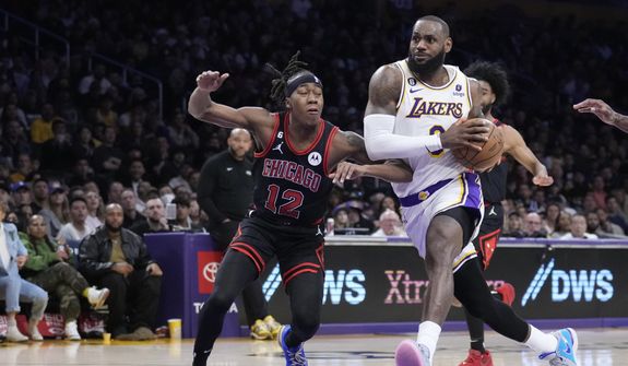 Los Angeles Lakers forward LeBron James drives to the basket past Chicago Bulls guard Ayo Dosunmu (12) during the second half of an NBA basketball game, Sunday, March 26, 2023, in Los Angeles. (AP Photo/Marcio Jose Sanchez)