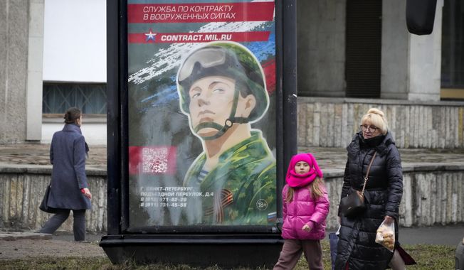 People walk past an army recruiting billboard with the words &quot;Military service under contract in the armed forces&quot; in St. Petersburg, Russia, Friday, March 24, 2023. A campaign to replenish Russian troops in Ukraine with more soldiers appears to be underway again, with makeshift recruitment centers popping up in cities and towns, and state institutions posting ads promising cash bonuses and benefits to entice men to sign contracts enabling them to be sent into the battlefield. (AP Photo)