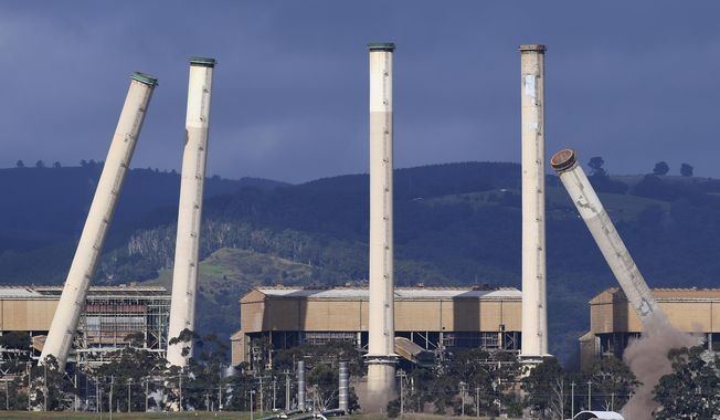 Some of the coal-burning Hazelwood Power Station&#x27;s eight chimneys begin to topple as they are demolished and the station is decommissioned in Hazelwood, Victoria, on May 25, 2020. The Australian government has taken, on Monday, March 27, 2023, a major step forward in implementing a key climate policy that would force major greenhouse gas polluters to reduce emissions with the minor Greens party pledging their support. (James Ross/AAP Image via AP)