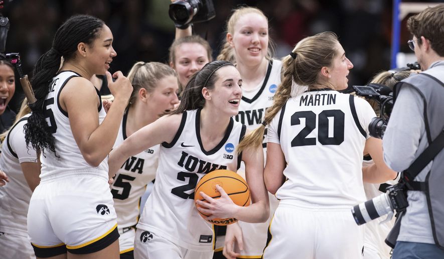 Iowa players, including guard guard Caitlin Clark, front center, forward Hannah Stuelke, front left, and guard Kate Martin (20) celebrate after an Elite 8 basketball game of the NCAA Tournament against Louisville, Sunday, March 26, 2023, in Seattle. Iowa won 97-83. (AP Photo/Caean Couto) **FILE**