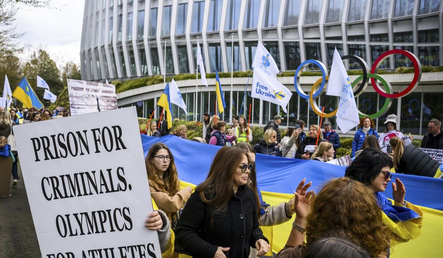 Members of the Geneva branch of Ukrainian society in Switzerland protest during a rally to urge International Olympic Committee to reconsider their decision of participation of Russian and Belarusian athletes under white neutral flag at the next 2024 Paris Olympic Games, in front of the IOC headquarters, in Lausanne, Switzerland, Saturday, March 25, 2023. (Jean-Christophe Bott/Keystone via AP) **FILE**