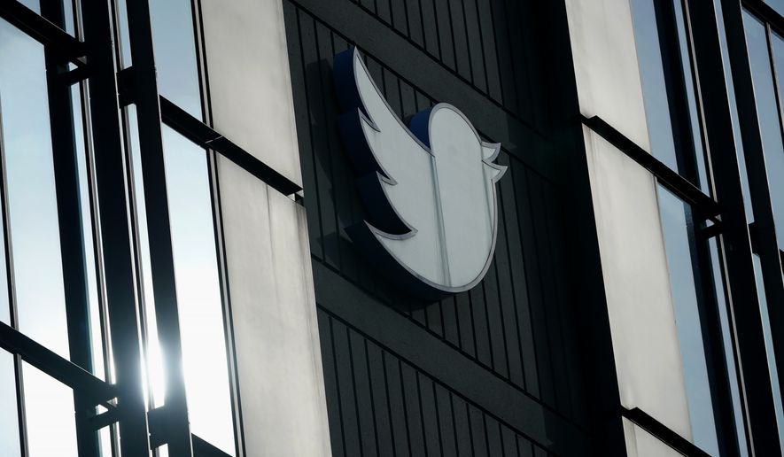A Twitter logo hangs outside the company&#x27;s offices in San Francisco, on Dec. 19, 2022. William Shatner, Monica Lewinsky and other prolific Twitter commentators — some household names, others little-known journalists — could soon be losing the blue check marks that helped verify their identity on the social media platform. (AP Photo/Jeff Chiu, File)