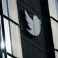 A Twitter logo hangs outside the company&#x27;s offices in San Francisco, on Dec. 19, 2022. William Shatner, Monica Lewinsky and other prolific Twitter commentators — some household names, others little-known journalists — could soon be losing the blue check marks that helped verify their identity on the social media platform. (AP Photo/Jeff Chiu, File)