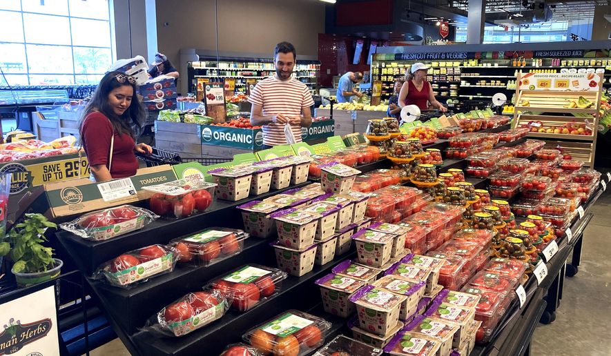 Shoppers check over the produce and shop at a grocery store in Glenview, Ill., Monday, July 4, 2022.  (AP Photo/Nam Y. Huh)