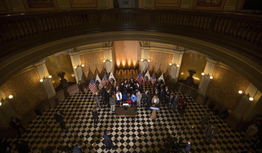 Gov. Gavin Newsom shakes hands with legislators and state officials in the Capitol rotunda in Sacramento before signing a bill aimed at addressing gas price gouging, Tuesday, March 28, 2023, in Sacramento, Calif. (Xavier Mascareñas/The Sacramento Bee via AP)