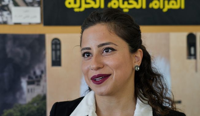 Deputy Regional Director for the Middle East &amp; North Africa Aya Majzoub, speaks during an interview with The Associated Press in Beirut, Lebanon, Tuesday, March 28, 2023. Leading international rights group Amnesty International on Tuesday decried what it said were double standards by Western countries, which rallied behind a &quot;robust response&quot; to Russia&#x27;s invasion of Ukraine but remain &quot;lukewarm&quot; on issues of human rights violations in the Middle East. The Arabic Words in the background read &quot;Woman, life, freedom.&quot; (AP Photo/Bilal Hussein)