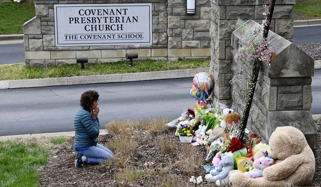 Robin Wolfeden prays in front of a makeshift memorial at the entrance to The Covenant School Tuesday, March 28, 2023, in Nashville, Tenn. Three children and three school staff members were killed by a former student in Monday&#x27;s mass shooting. (Mark Zaleski /The Tennessean via AP)