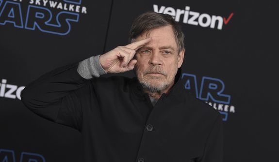 Mark Hamill salutes as he arrives at the world premiere of &quot;Star Wars: The Rise of Skywalker&quot; in Los Angeles on Dec. 16, 2019. When air raid alarms sound in Ukraine, they also trigger a downloadable app that has been voiced by “Star Wars” actor Mark Hamill. With his calming baritone, he urges people to take cover. He also tells them when the danger has passed, signing off with “May the Force be with you.” In an interview with The Associated Press, the actor said he’s admiring Ukraine&#x27;s resilience from afar in California. (Jordan Strauss/Invision/AP,  File)