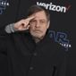 Mark Hamill salutes as he arrives at the world premiere of &quot;Star Wars: The Rise of Skywalker&quot; in Los Angeles on Dec. 16, 2019. When air raid alarms sound in Ukraine, they also trigger a downloadable app that has been voiced by “Star Wars” actor Mark Hamill. With his calming baritone, he urges people to take cover. He also tells them when the danger has passed, signing off with “May the Force be with you.” In an interview with The Associated Press, the actor said he’s admiring Ukraine&#x27;s resilience from afar in California. (Jordan Strauss/Invision/AP,  File)