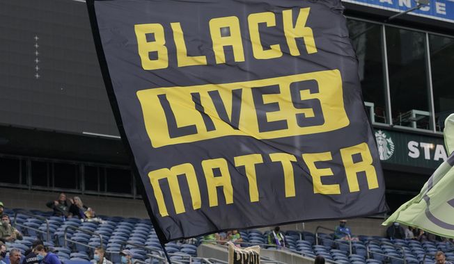 Seattle Sounders supporters fly a Black Lives Matter flag before an MLS soccer match against Atlanta United, May 23, 2021, in Seattle. On Wednesday, March 29, 2023, German sportswear company Adidas withdrew its opposition to a Black Lives Matter application with the U.S. Trademark Office two days after its filing. On Monday, March 27, Adidas submitted a notice of opposition with the office, saying in the filing that it took issue with Black Lives Matter Global Network Foundation&#x27;s application to trademark the use of three parallel yellow stripes on various items such as clothing and bags. (AP Photo/Ted S. Warren, File)