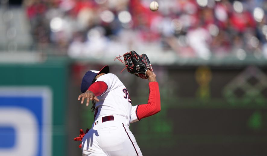 Washington Nationals shortstop CJ Abrams prepares to catch a fly ball that was hit by Atlanta Braves&#x27; Sean Murphy during the ninth inning of an opening day baseball game at Nationals Park, Thursday, March 30, 2023, in Washington. (AP Photo/Alex Brandon)
